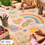 Children drawing on a large paper with colorful crayons at a table.